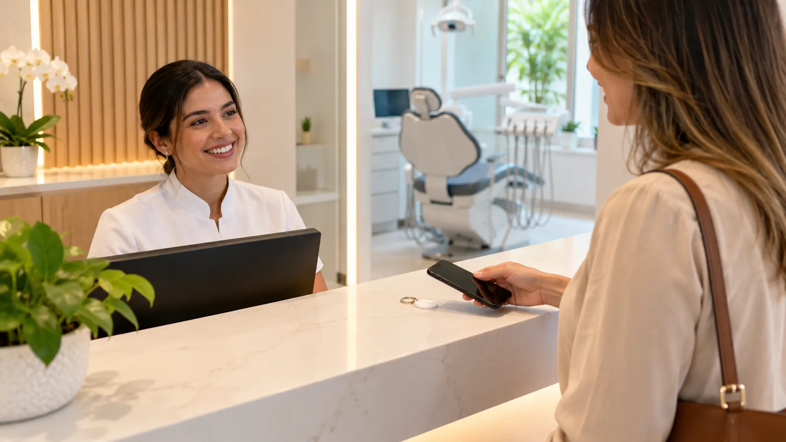 Paciente aproximando o celular de um chaveiro NFC no balcão da recepção de uma clínica odontológica