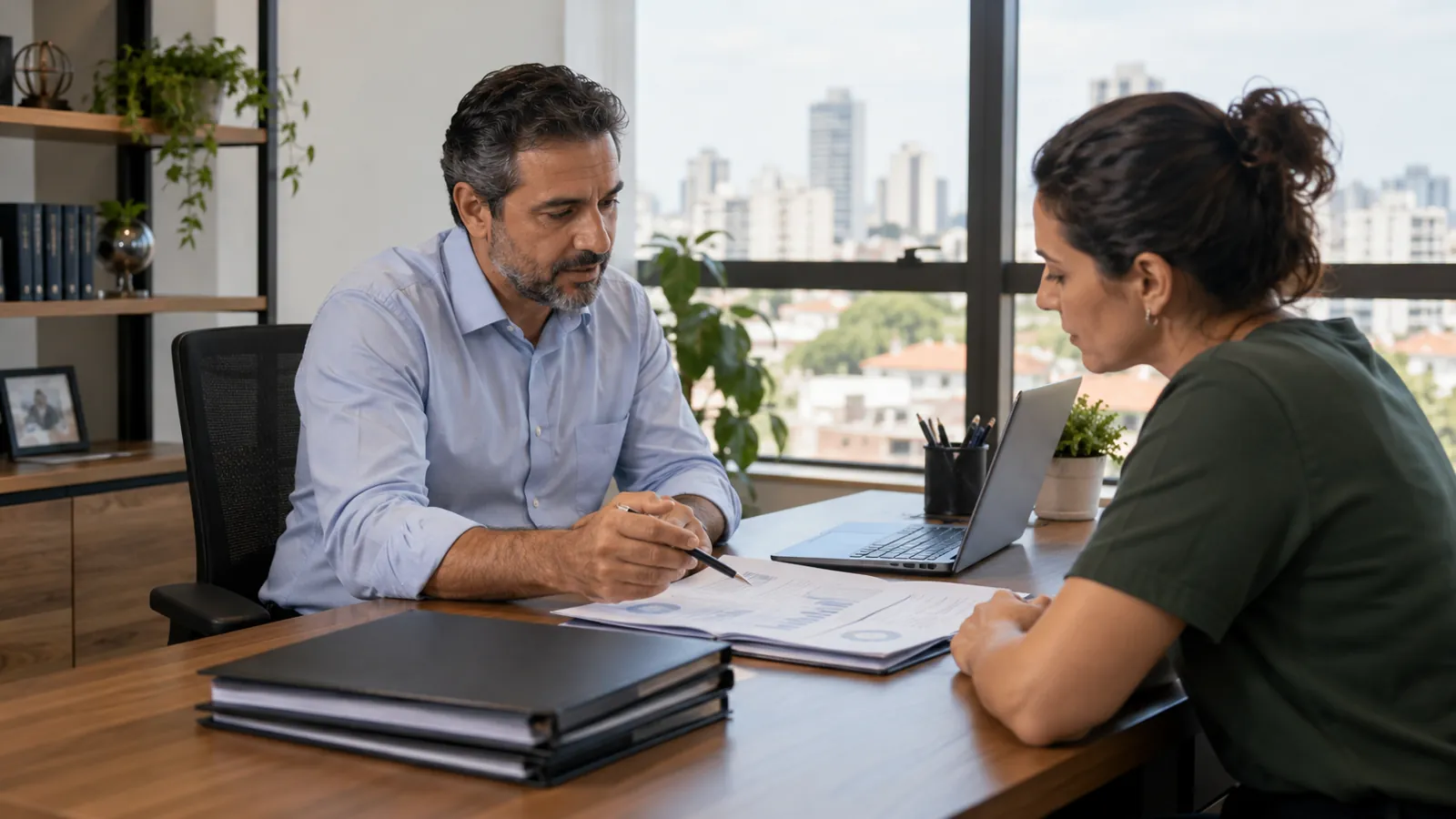 Contador explicando documentos para uma pequena empresária em escritório de contabilidade